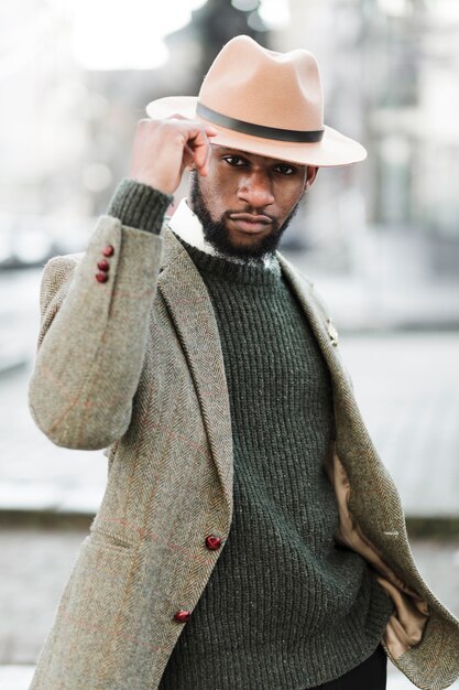 man with hat posing outdoors