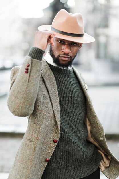 Man with hat posing outdoors