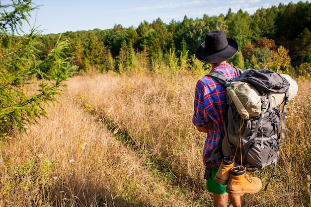 Foto gratuita uomo con cappello in viaggio nel campo