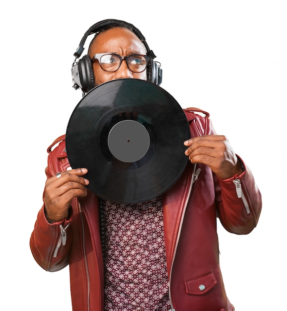 Man with headphones covering his mouth with a vinyl record