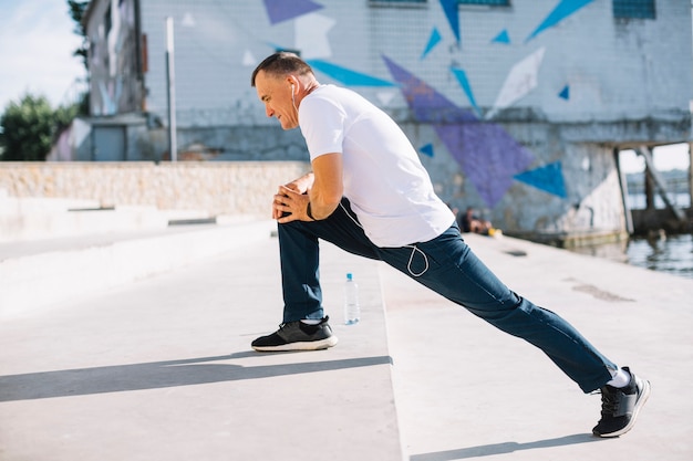 Man with headphones in his ears doing exercises