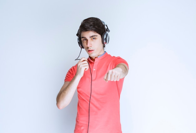 Man with headphones longing his fist ahead.