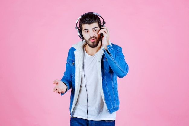 Man with headphones looks confused