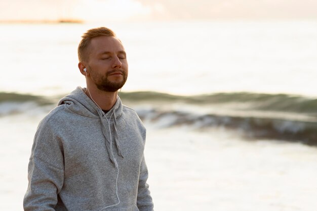 Man with headphones relaxing outdoors with copy space