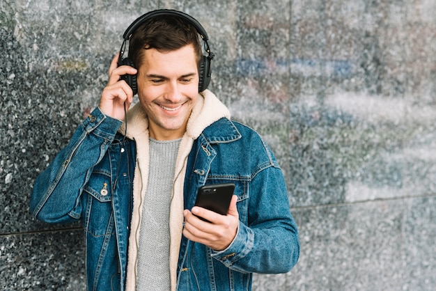 Foto gratuita uomo con cuffie e smartphone in ambiente urbano