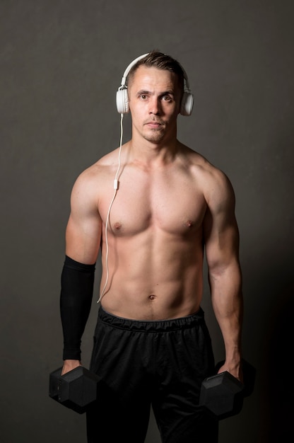 Free photo man with headphones and weights