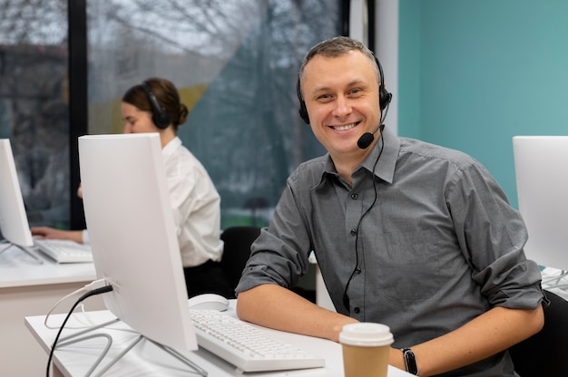 Man with headphones working in a call center office