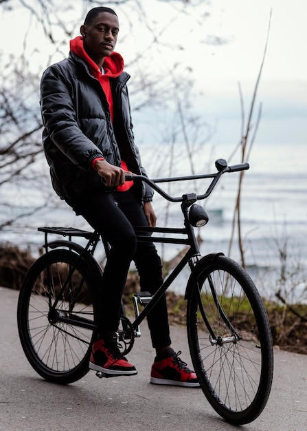 Free photo man with his bicycle next to a lake