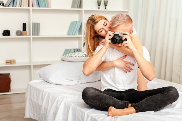 カメラで写真を撮る彼のガールフレンドを持つ男