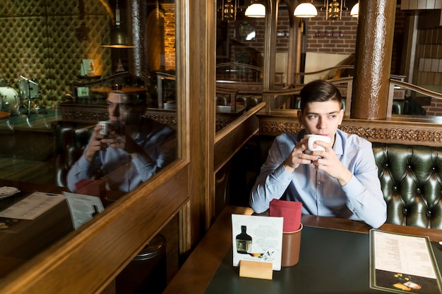 Free photo man with hot drink relaxing in cafe