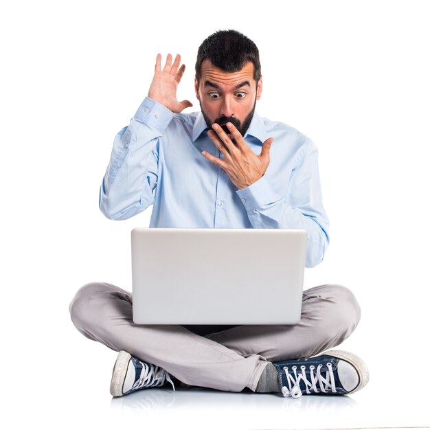 Man with laptop doing surprise gesture