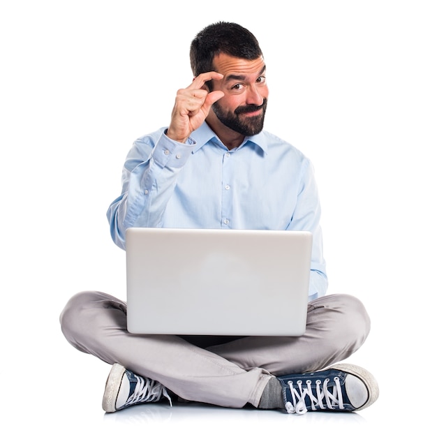 Man with laptop doing tiny sign