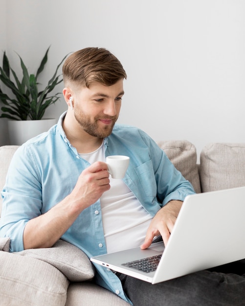Мужчина с ноутбуком пьет кофе