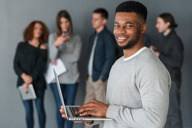 Man with laptop in front of people