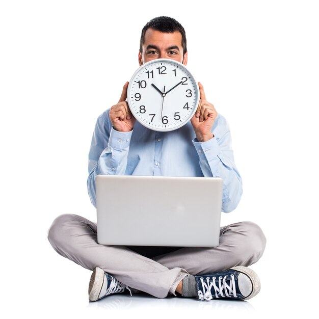 Man with laptop holding a watch