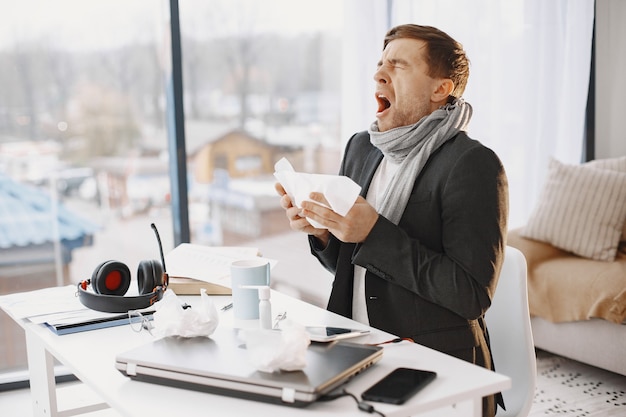 Free photo man with a laptop is suffering with cough and feeling bad. businessman at home.