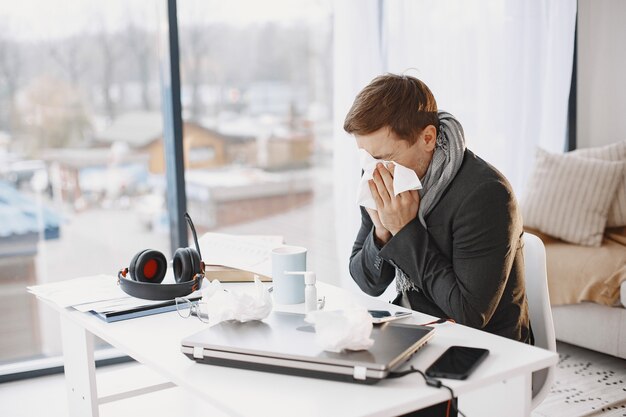 ノートパソコンを持っている男性は咳に苦しんでいて気分が悪いです。自宅でビジネスマン。