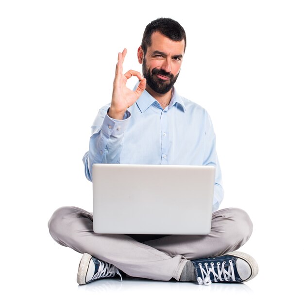 Man with laptop making OK sign