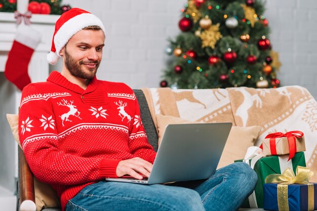 Man with laptop near present boxes 