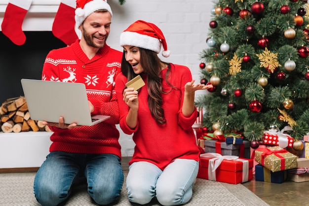 Man with laptop near woman with credit card