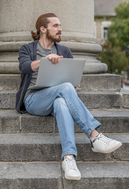 Man with laptop in steps