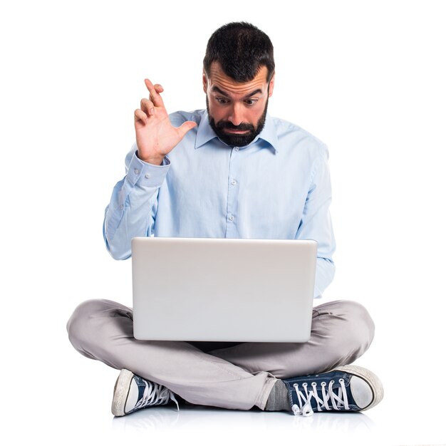 Man with laptop with his fingers crossing