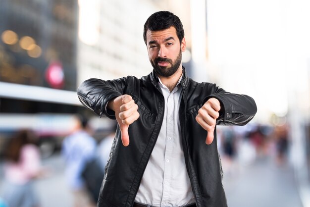 Man with leather jacket doing bad signal
