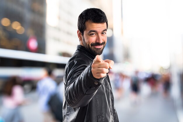 Man with leather jacket pointing to the front