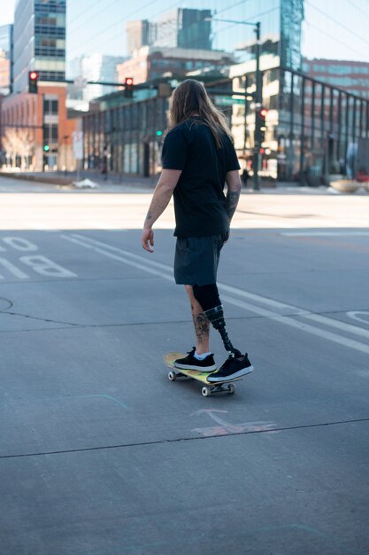 Человек с инвалидностью ног катается на скейтборде в городе