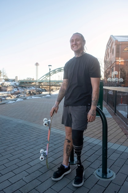 Foto gratuita uomo con disabilità alle gambe che fa skateboard in città