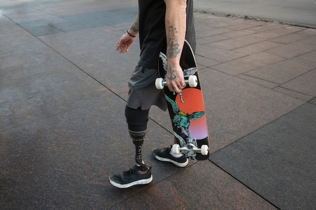 무료 사진 도시에서 다리 장애 스케이트보드를 타는 남자