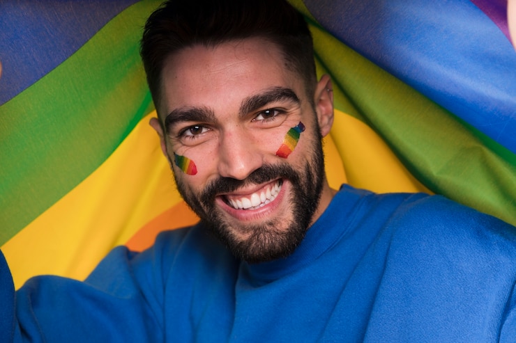 無料Photo ゲイパレードの顔にlgbtの虹を持つ男