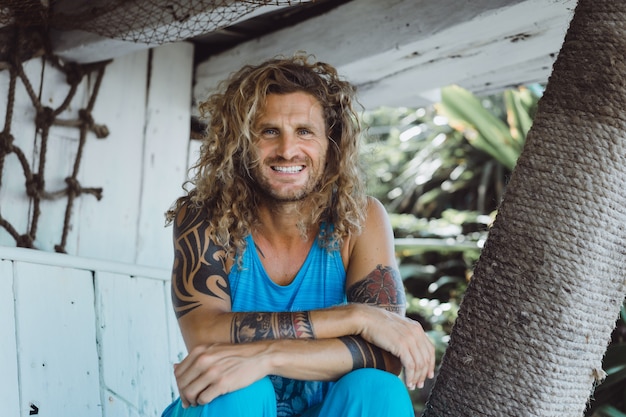 Free photo a man with long curly hair in a fishing location. fisherman on the ocean