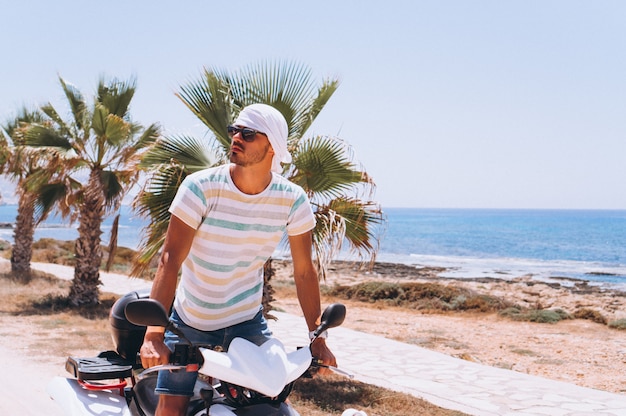 Man with map travalling on atv by the sea