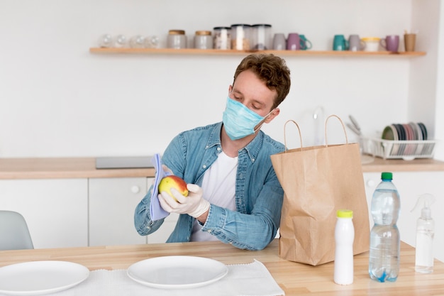 Free photo man with mask cleaning fruit