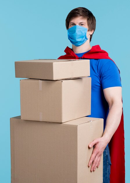 Man with mask holding boxes