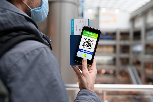 Free photo man with mask holding smartphone