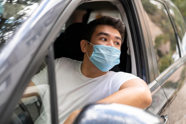 Man with medical mask driving