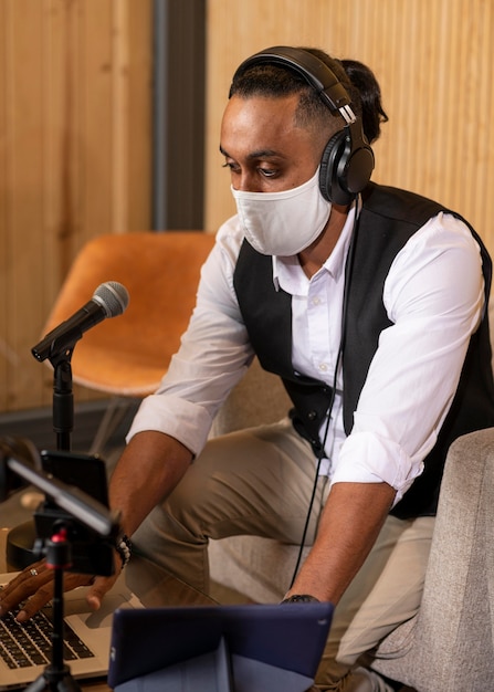 ラジオ局で話し合っている医療用マスクを持った男