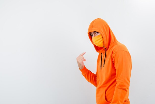 The man with medical mask is showing himself with forefinger on white background