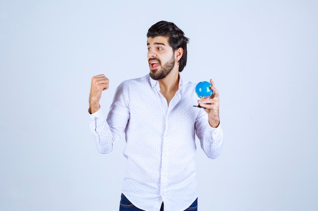 Uomo con un mini globo che mostra il pugno