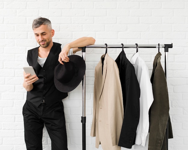 Man with mobile phone next to wardrobe