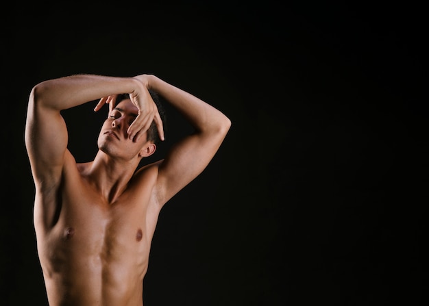 Man with naked torso folding hand before face
