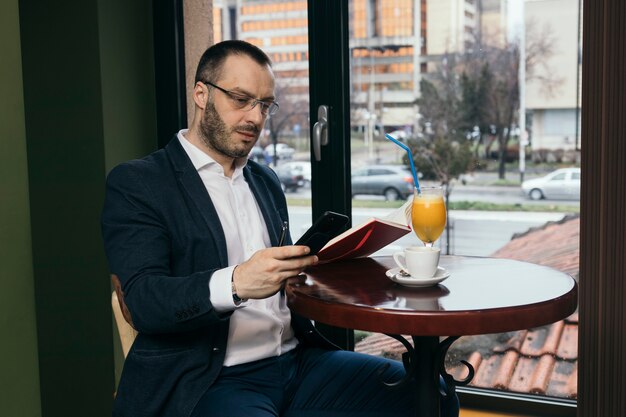 Man with notebook using smartphone