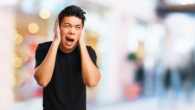 Man with pain covering his ears