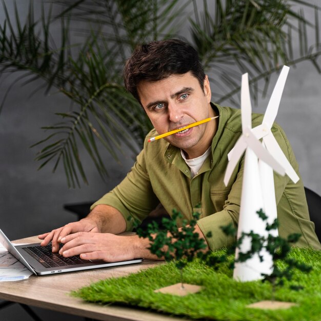 Man with pencil in his mouth working on an eco-friendly wind power project