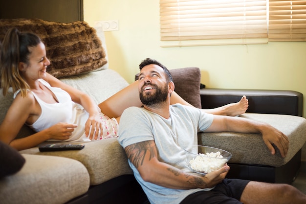 Man with popcorn looking at his happy wife