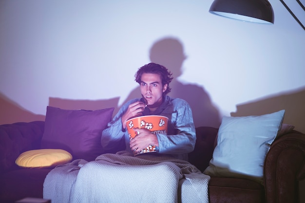 Man with popcorn watching a movie