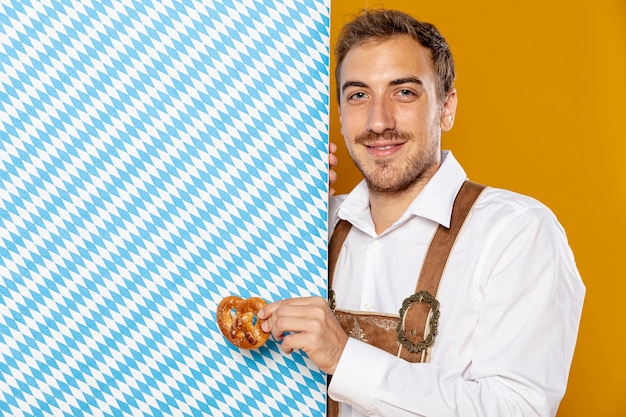 Free photo man with pretzel and patterned sign