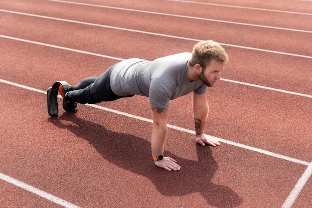 Man with prosthetic leg doing high plank full shot